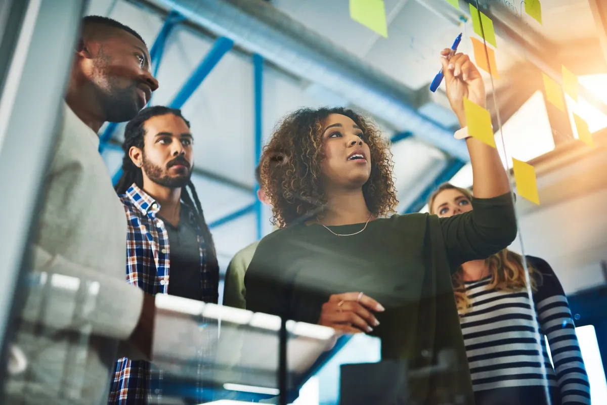 Team planning together at a glass wall covered in sticky notes